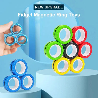 An image featuring Valga's colorful 3Pcs Magnetic Rings Anti-Stress toys used for fidgeting. The rings come in various vibrant colors, including blue, green, red, yellow, and black. Some are being held in hand while others are stacked on a blue platform. Text at the top says "NEW UPGRADE Fidget Magnetic Ring Toys".