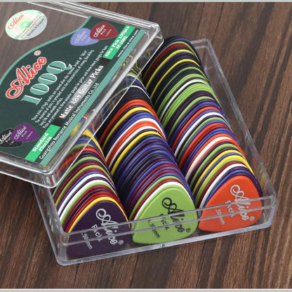 A clear plastic box labeled "Valga Guitar Picks 100pc" contains an assortment of durable guitar picks made from ABS plastic. The vibrant picks, in colors like green, purple, red, yellow, and blue, are perfect for acoustic electric bass guitars. The box rests neatly on a wooden surface.