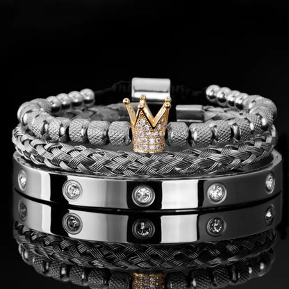 Experience the elegance of Valga's Diamond Roman Bracelets, a sophisticated collection featuring luxury beaded, braided, and stainless steel cuff designs. The highlight is a gold crown charm adorned with small diamonds sitting atop a beaded bracelet. The stainless steel cuffs are beautifully embellished with sparkling stones set against a glossy black background for an exquisite touch.