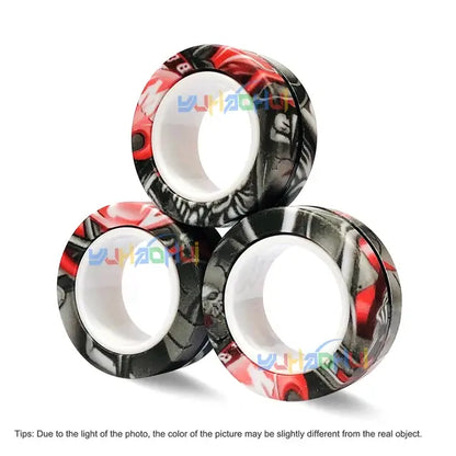 Three magnetic rings are arranged in a pyramid formation. Each ring features a black, white, and red design with abstract patterns. A watermark with the text "YIHAORUI" spans across the image. At the bottom, there is a small note about color variations to reduce anti-stress triggers from Valga's 3Pcs Magnetic Rings Anti-Stress set.