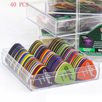 A clear plastic container holds an assortment of colorful, durable Valga Guitar Picks arranged neatly in rows. Each ABS plastic pick has "Valga" printed on it, and they come in various colors, including purple, green, and multicolored patterns. The text "40 PCS" is in red at the top left corner.