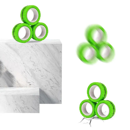 Three Valga 3Pcs Magnetic Rings Anti-Stress arranged in a triangle atop a white marble surface. One magnetic ring is shown mid-air, blurred to depict movement. Another ring appears to have cracked the surface below it, indicating impact.